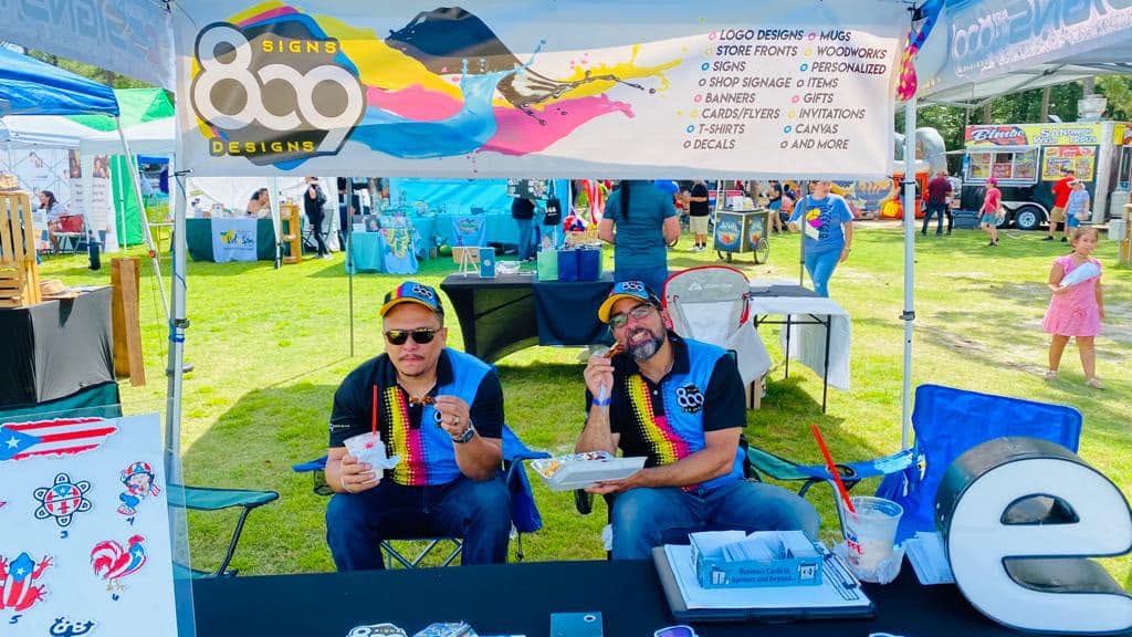 809 Signs and Designs booth showing signs, shirts and printed products